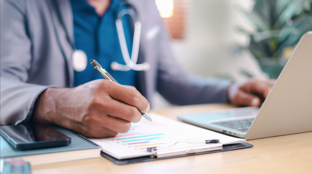 Doctor with a pen in her hand writing down a patient's work order on her clipboard.